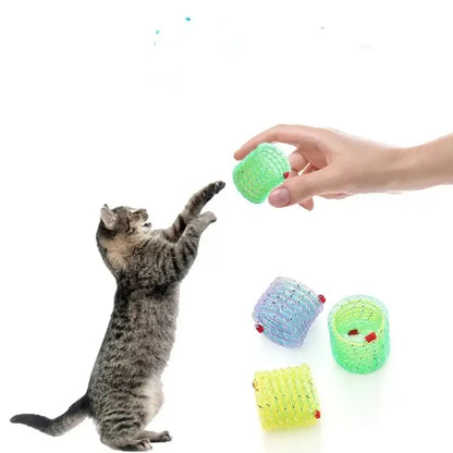 Tabby cat reaching up to play with a colorful toy ball.