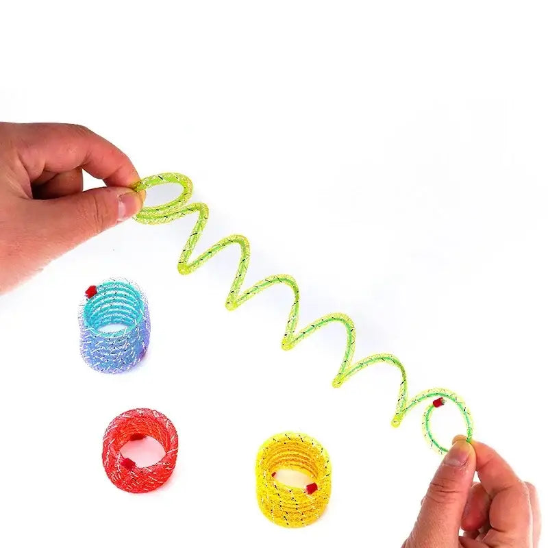 Hands stretching a neon green spiral spring toy with colorful beaded rings below it.