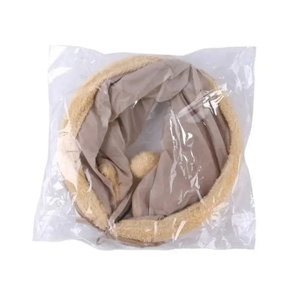 Beige and gray circular neck pillow sealed in clear plastic packaging.