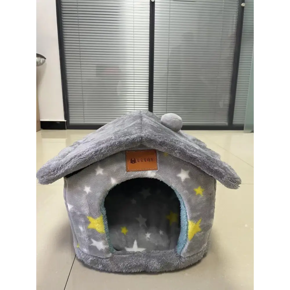 Plush gray pet house with star patterns and a domed roof.