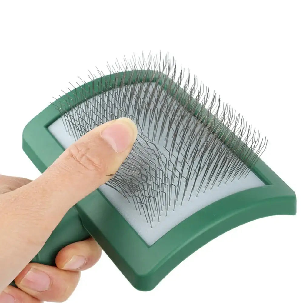 Green pet slicker brush with metal bristles and a curved surface.