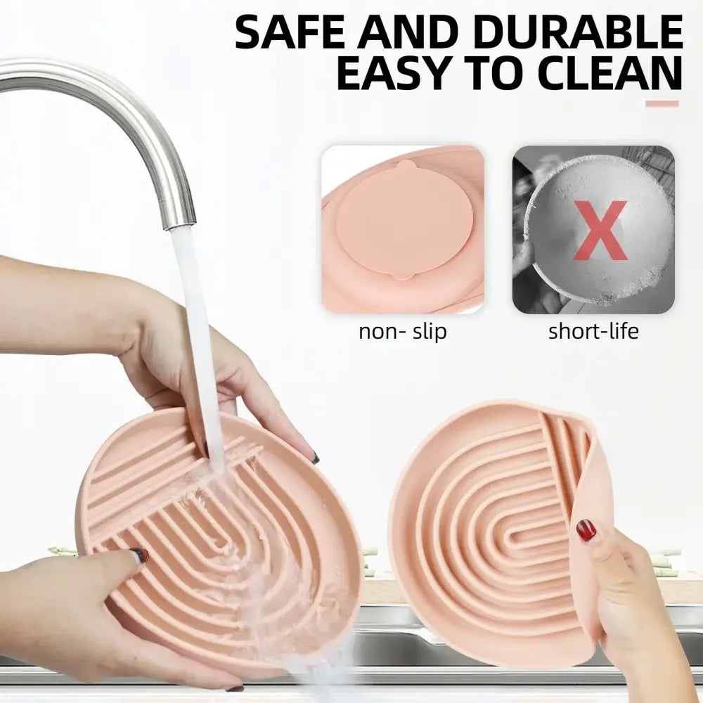 Pink heart-shaped silicone dish scrubber with grooved cleaning ridges.