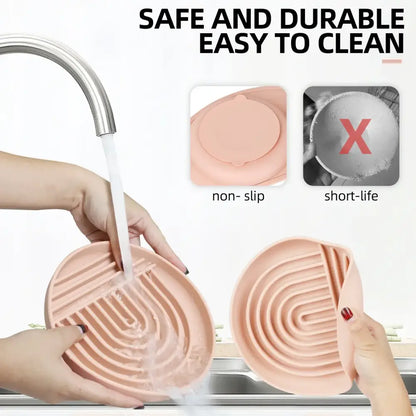 Pink heart-shaped silicone dish scrubber with grooved cleaning ridges.