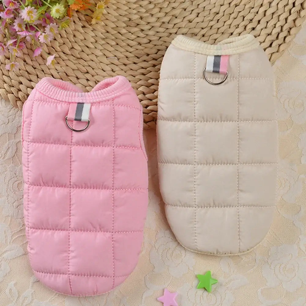 Two quilted pet vests in pink and white colors.